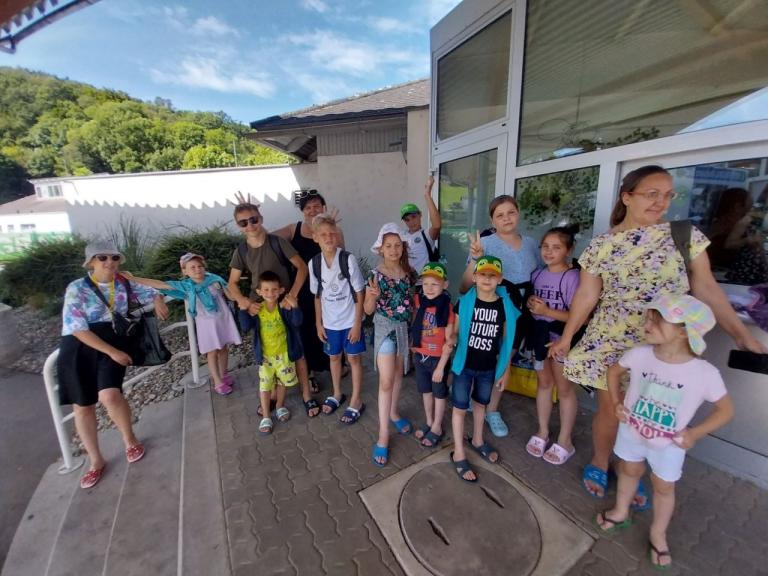 Kinder und Erwachsene stehen für ein Gruppenfoto zusammen