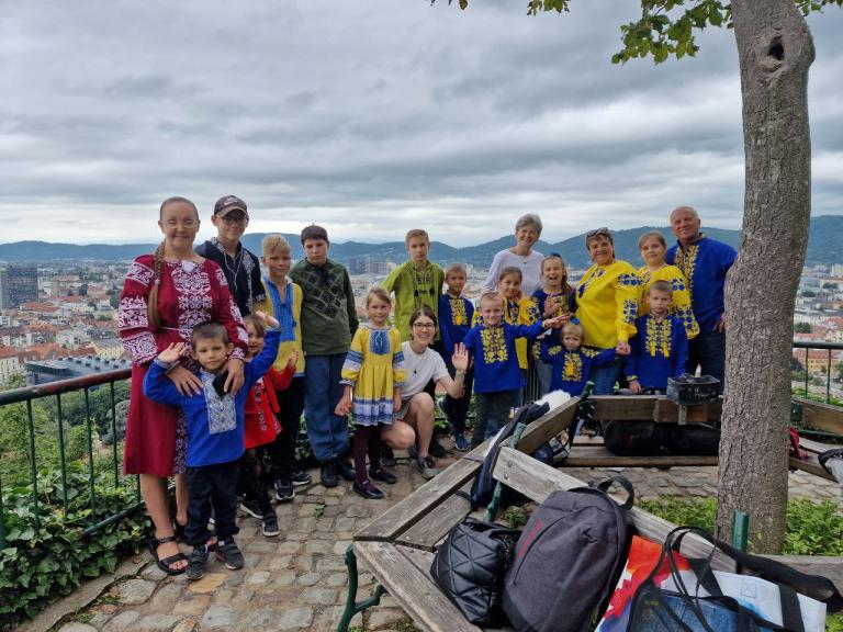 Kinder und Erwachsene stehen für ein Gruppenfoto am Schlossberg Graz zusammen