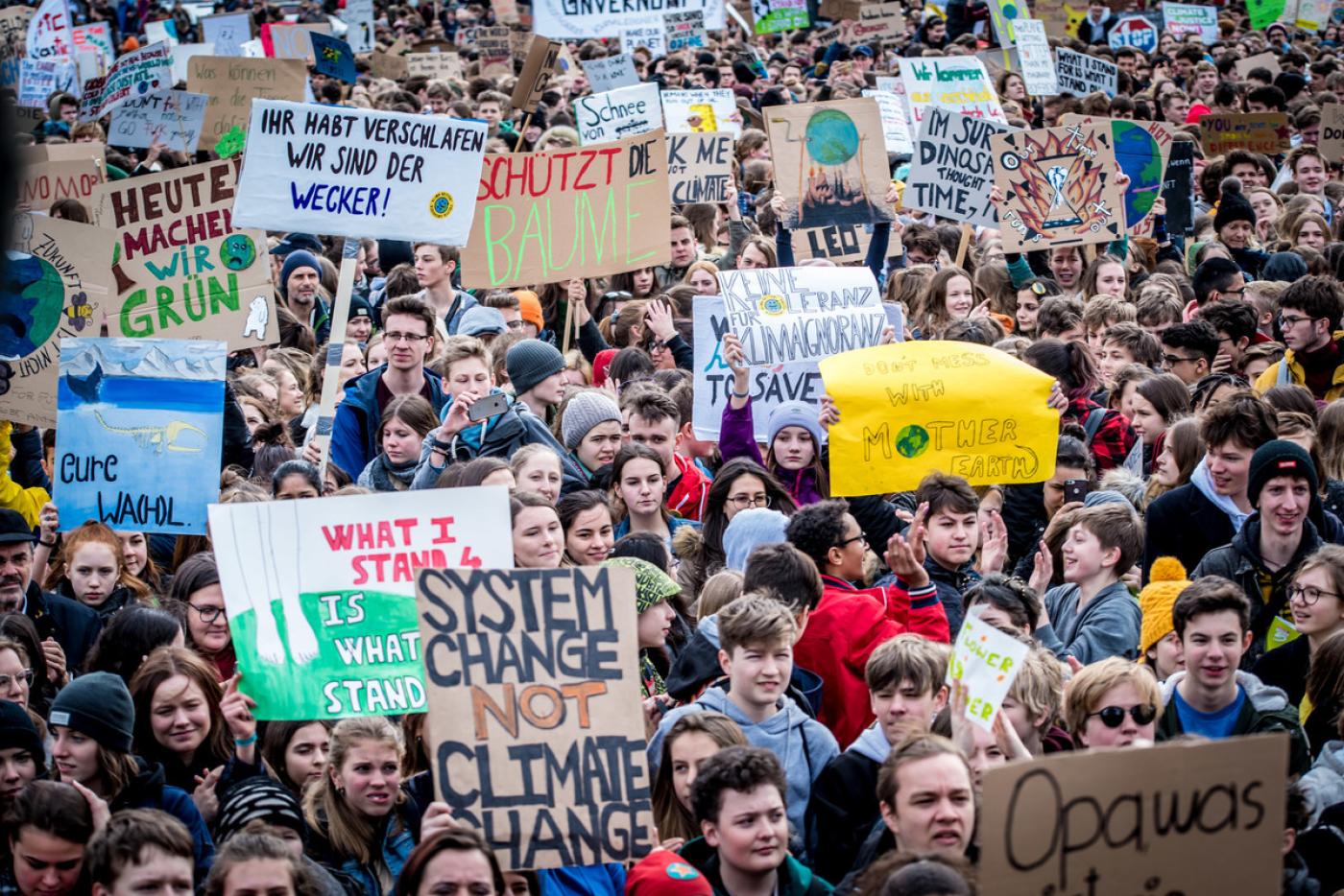 Viele junge Menschen mit Demo-Schildern 