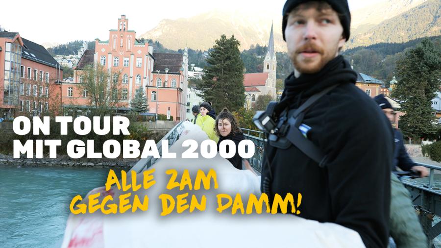 Konstantin auf einer Brücke in Innsbruck. Im Hintergrund sind andere Aktivist:innen zu sehen, wie sie einen Banner über die Brücke droppen.