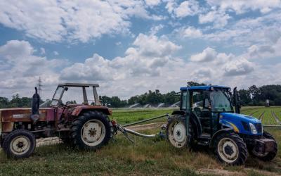 Ein alter und ein neuer Traktor stehen am Feld