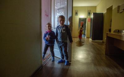 Zwei Kinder schauen neugierig aus dem Zimmer 