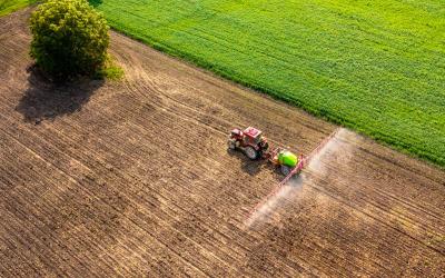 Traktor sprüht Pestizide, Aufnahme von oben als Luftbild