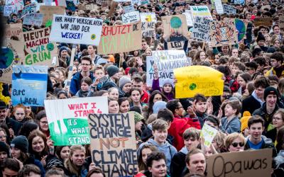 Viele junge Menschen mit Demo-Schildern 