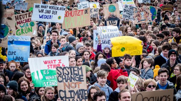 Viele junge Menschen mit Demo-Schildern 