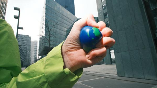 Hand zerdrückt kleinen Ball der aussieht wie Erden